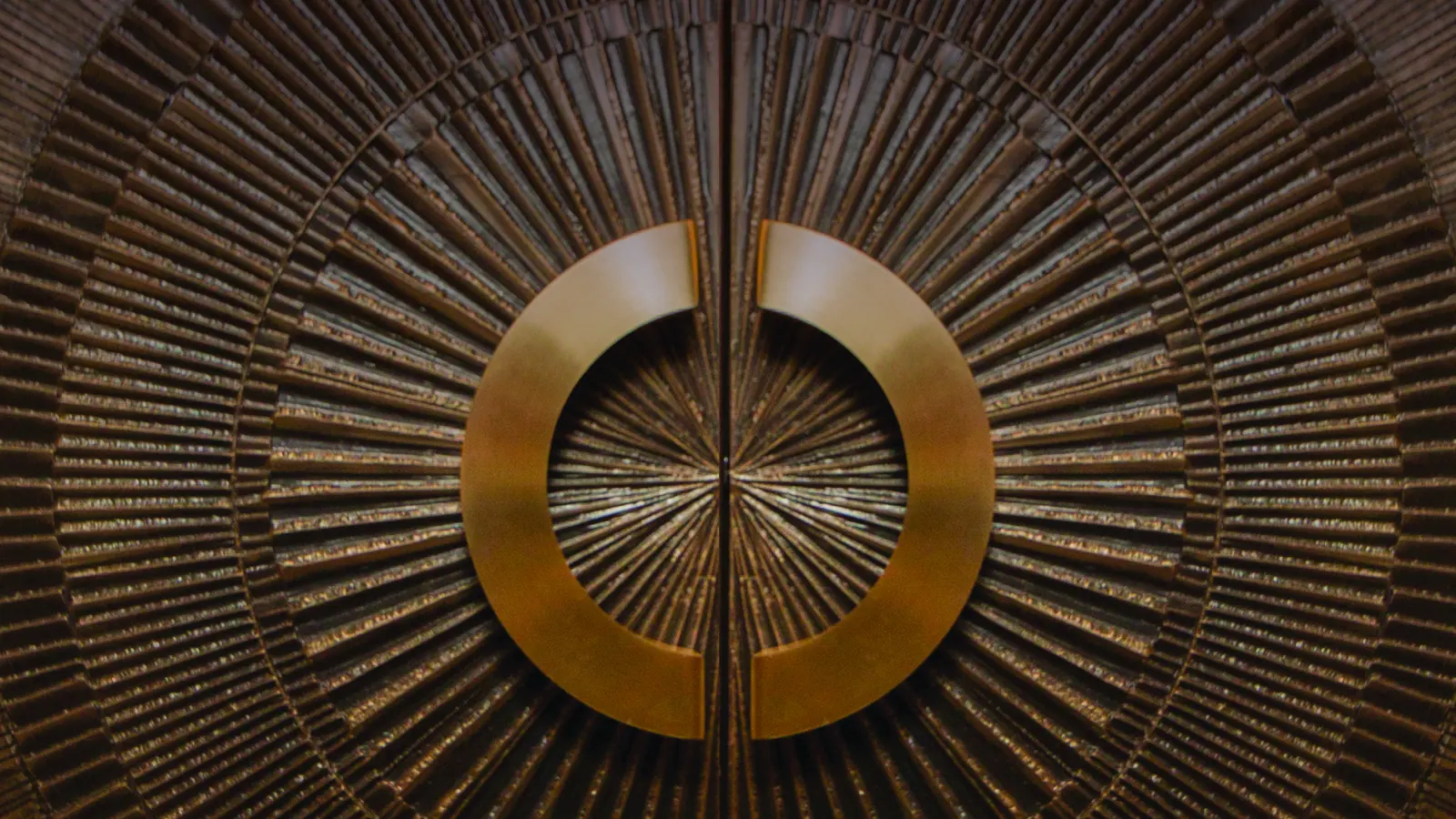 Close view of carved wooden doors with a polished brass ring